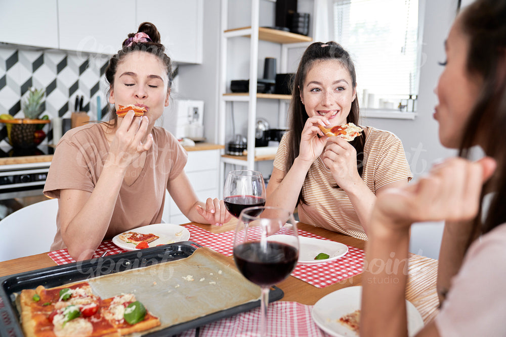 Friends eating delicious homemade pizza