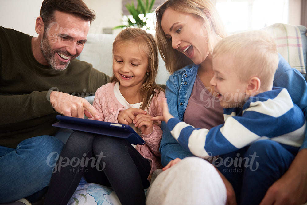 Family with tablet spending time together in living room