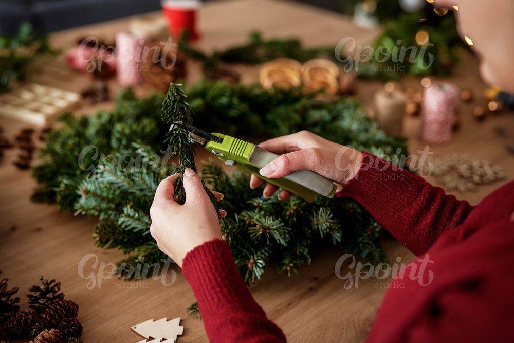 Table full of decorations and making Christmas wreaths