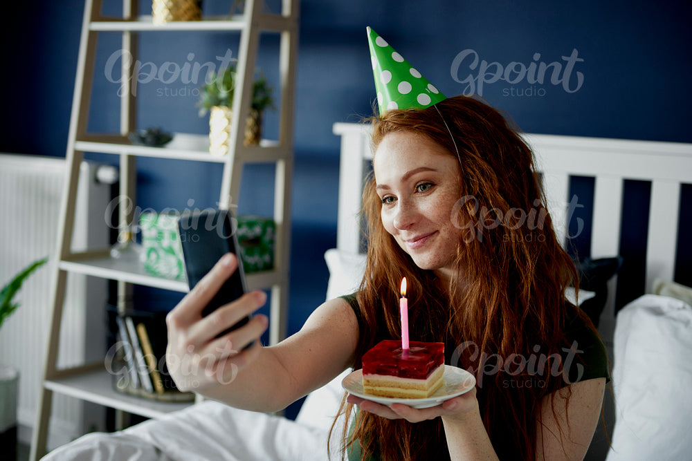 Woman taking a selfie with birthday cake