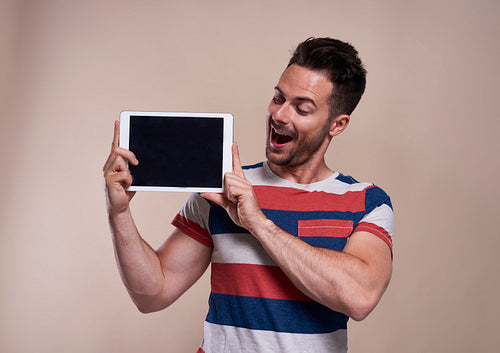 Young man showing a tablet in studio shot