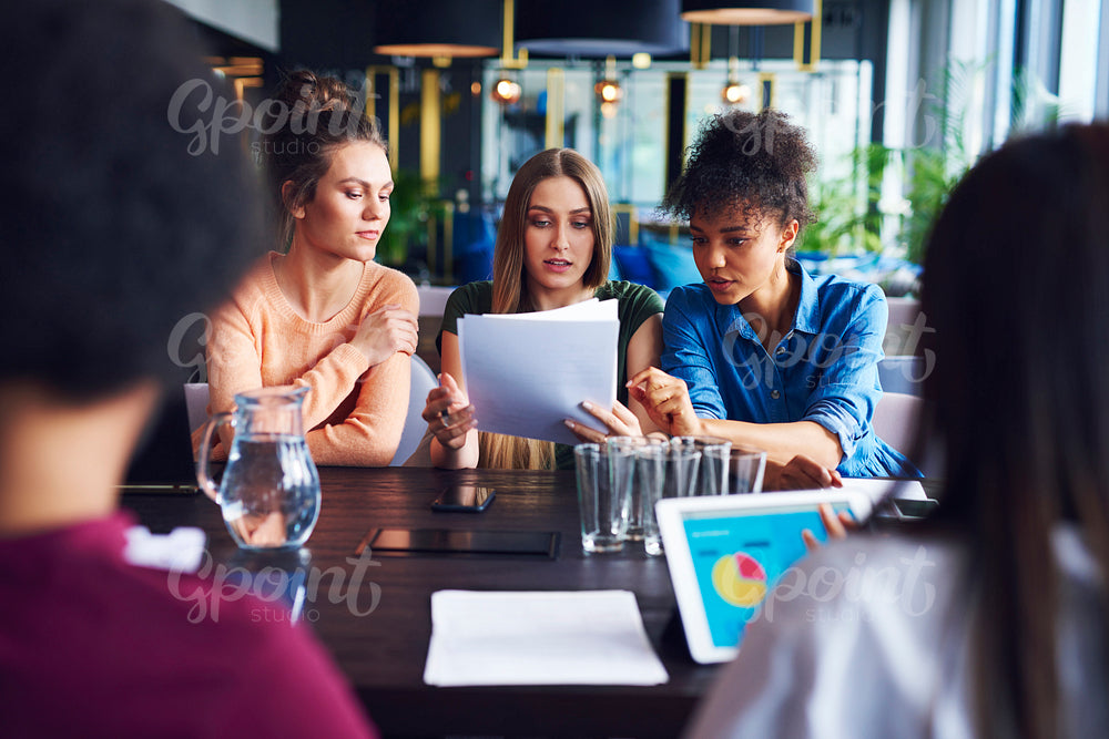 Three businesswomen analyzing the documents during business meeting