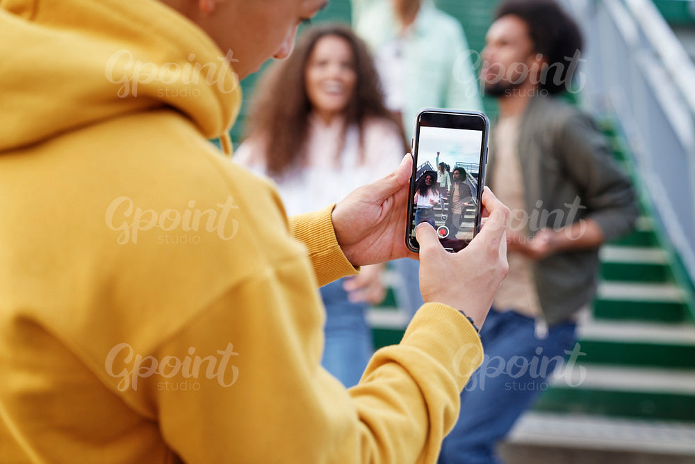 Young man taking pictures of his friends