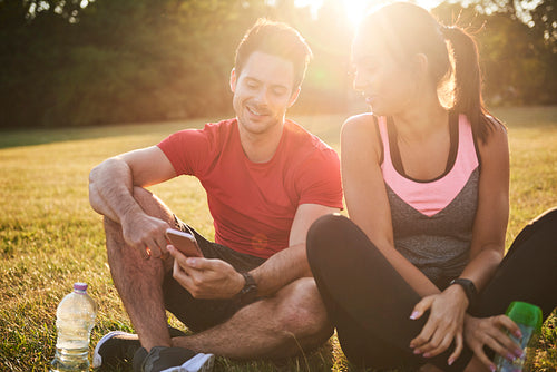 Young couple using mobile phone after hard workout