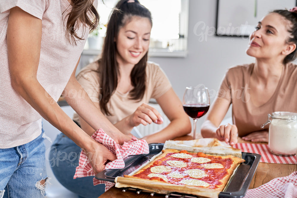 Three friends testing a homemade pizza crust
