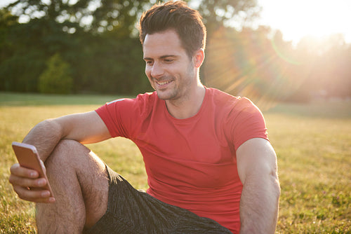 Smiling man using mobile phone after workout