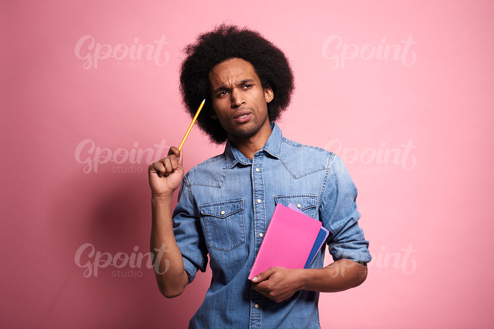 African man holding a pencil and thinking of something.