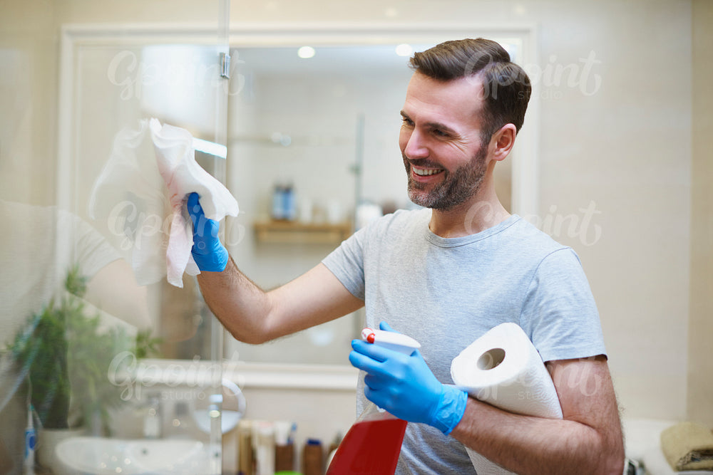 Happy man cleaning his home