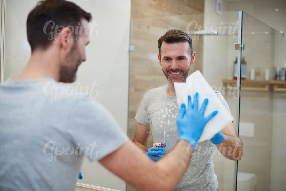 Happy man cleaning his home