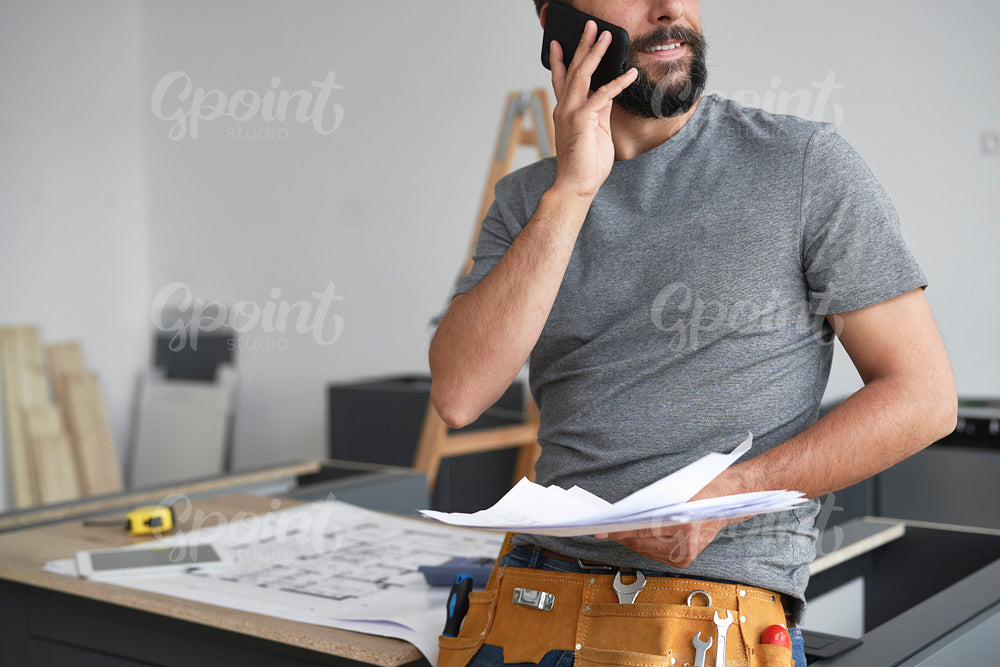 Carpenter discussing projects with the client by phone