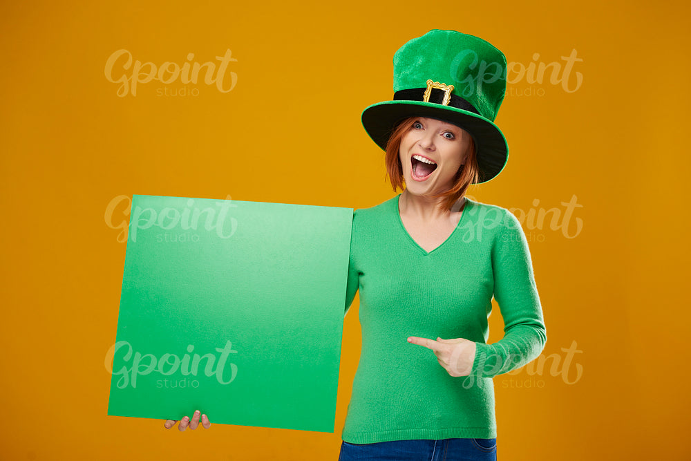 Portrait of screaming leprechaun pointing at banner with copy space