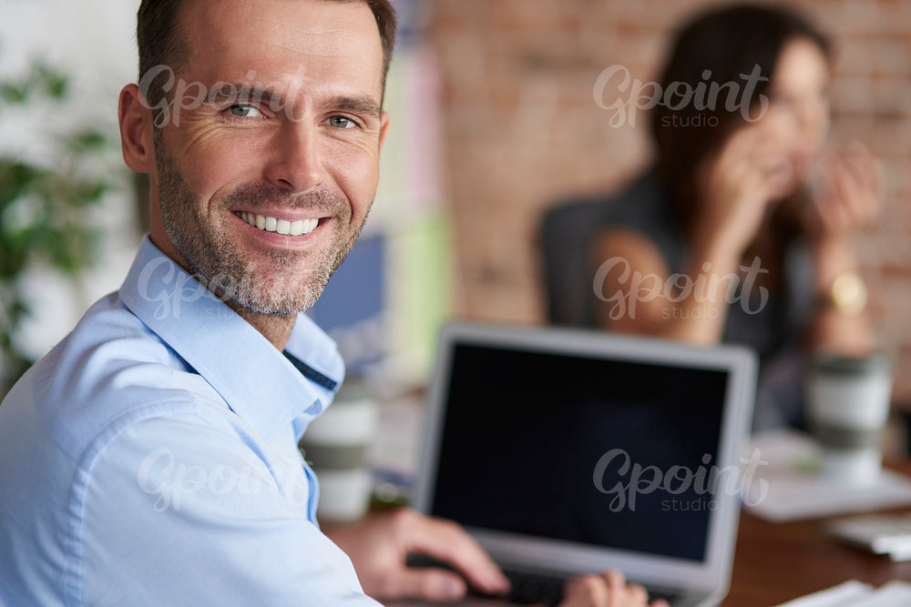 Portrait of cheerful man in front of computer