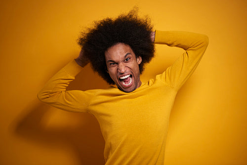 Screaming Afroamerican man on yellow background