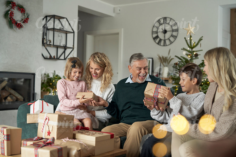 Multi generation caucasian family opening Christmas presents at home