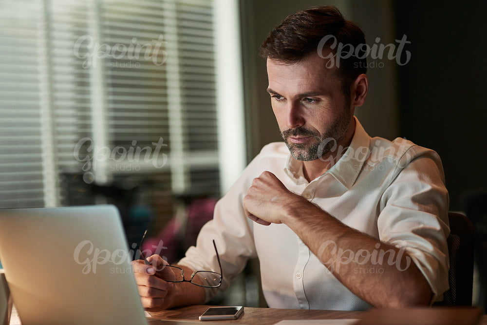 Focused businessman using a laptop at night