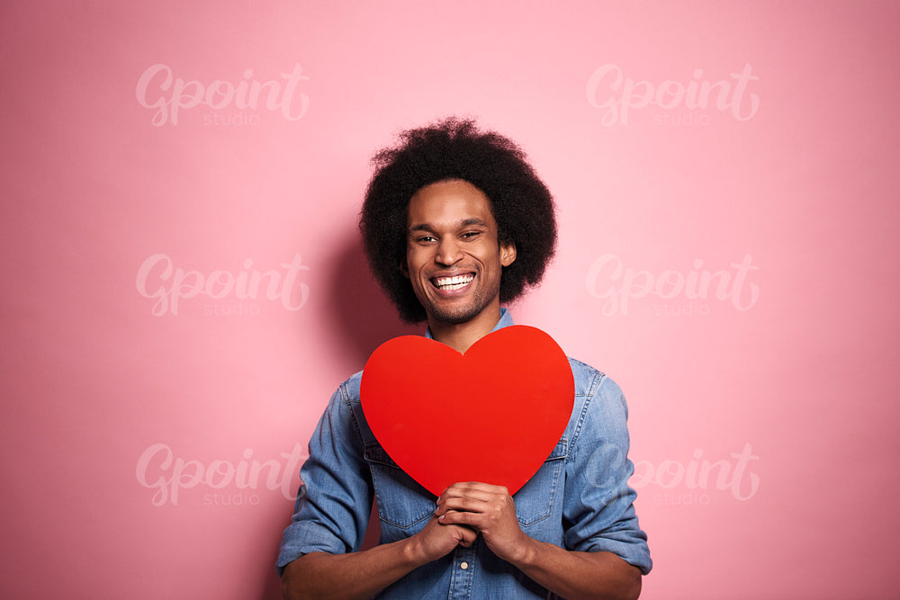 Happiness African man with big heart in studio shot.