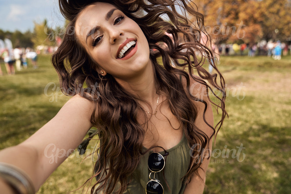 Smiling caucasian woman making selfie at music festival 