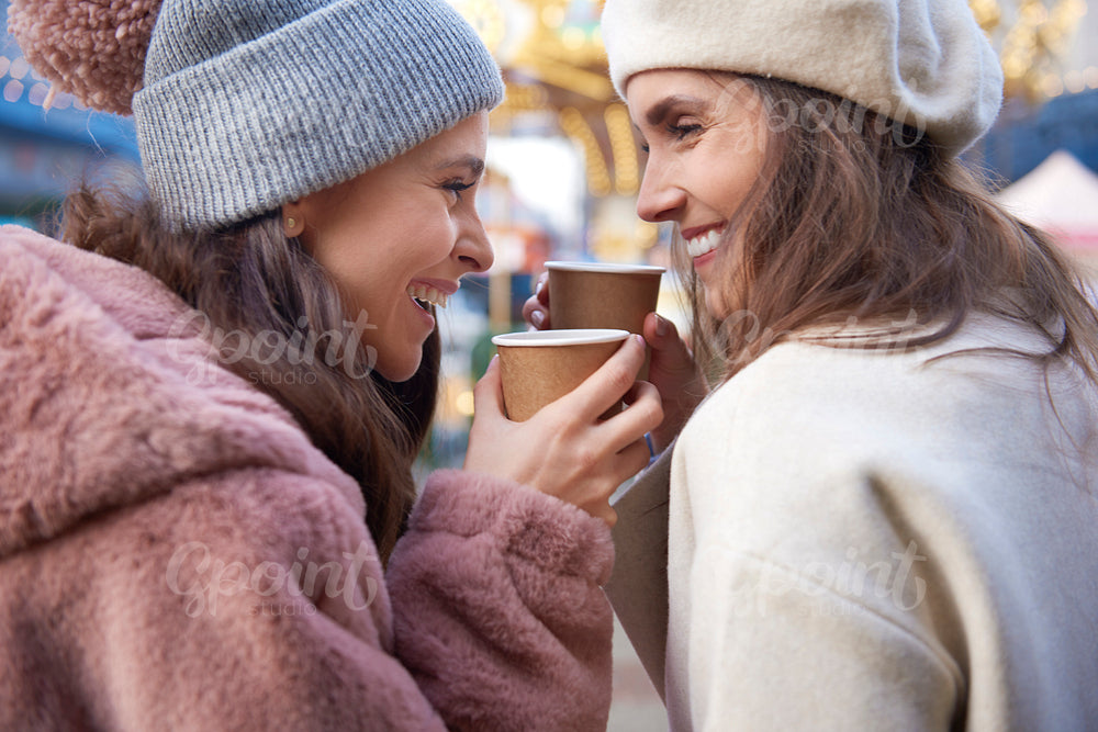 Close up of women drinking mulled wine outdoors
