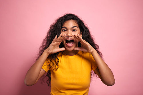Young African woman screaming loudly in a studio shot.