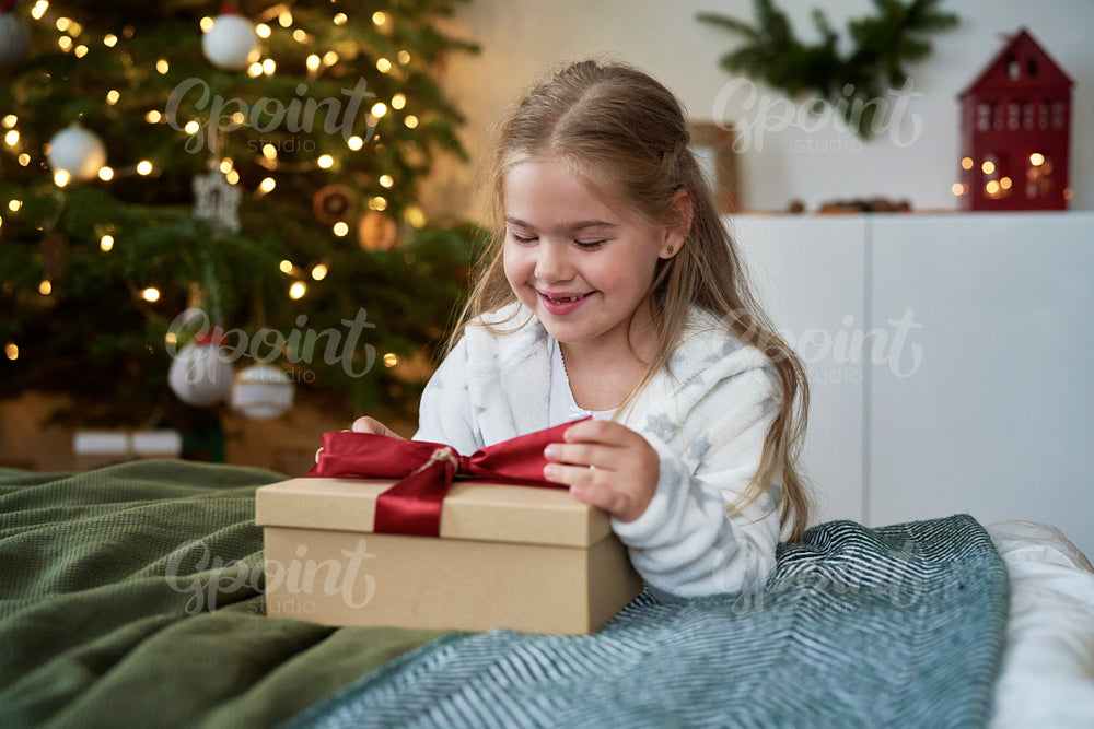 Little girl opening the Christmas present 