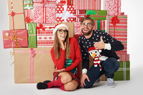 Wall of Christmas presents and cheerful couple