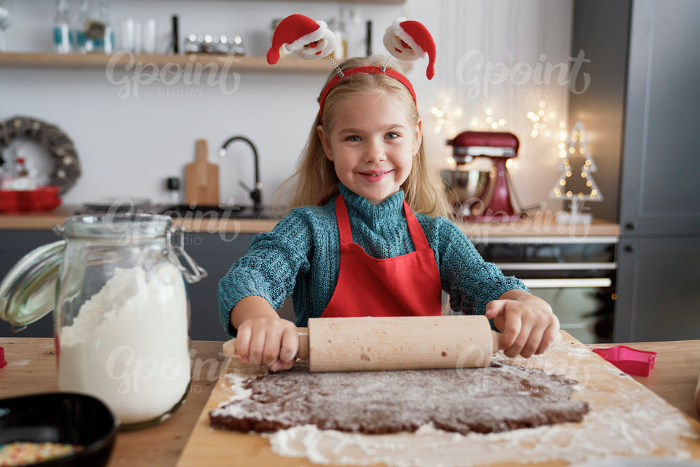Portrait of girl rolling gingerbread dough