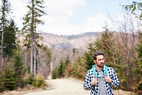 Front view of hiking man with backpack admiring at view