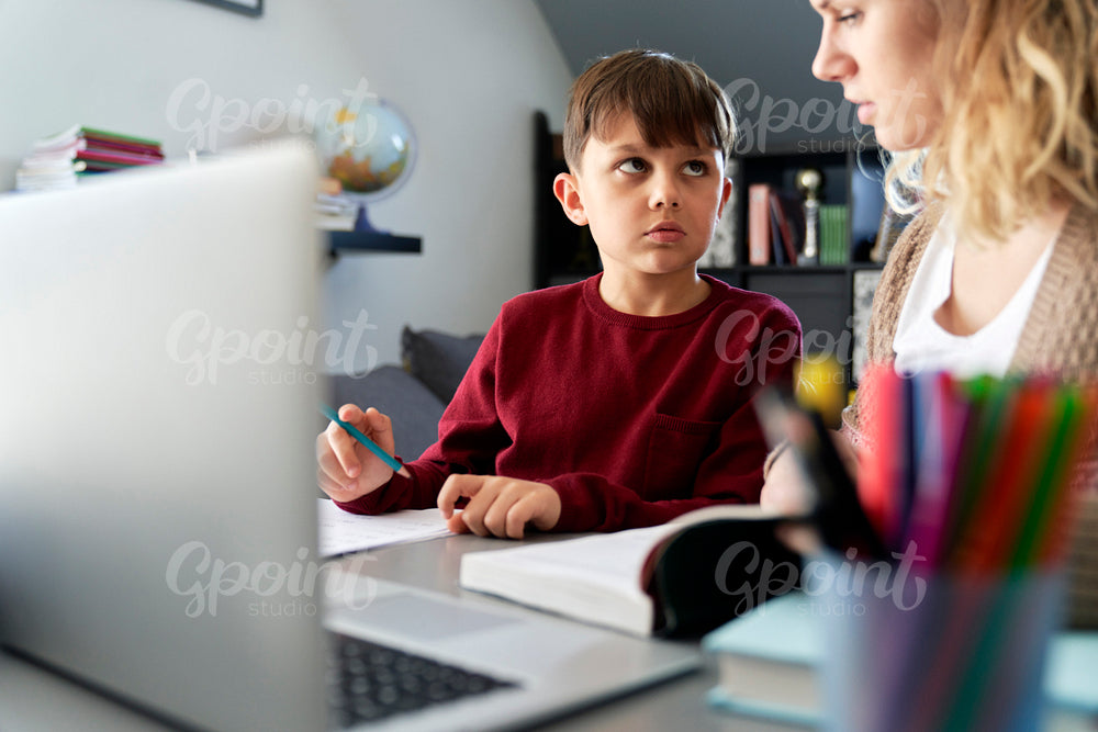 Boy listening while homeschooling mom teaches