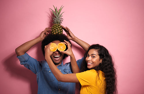 Young African couple having fun with exotic fruits.