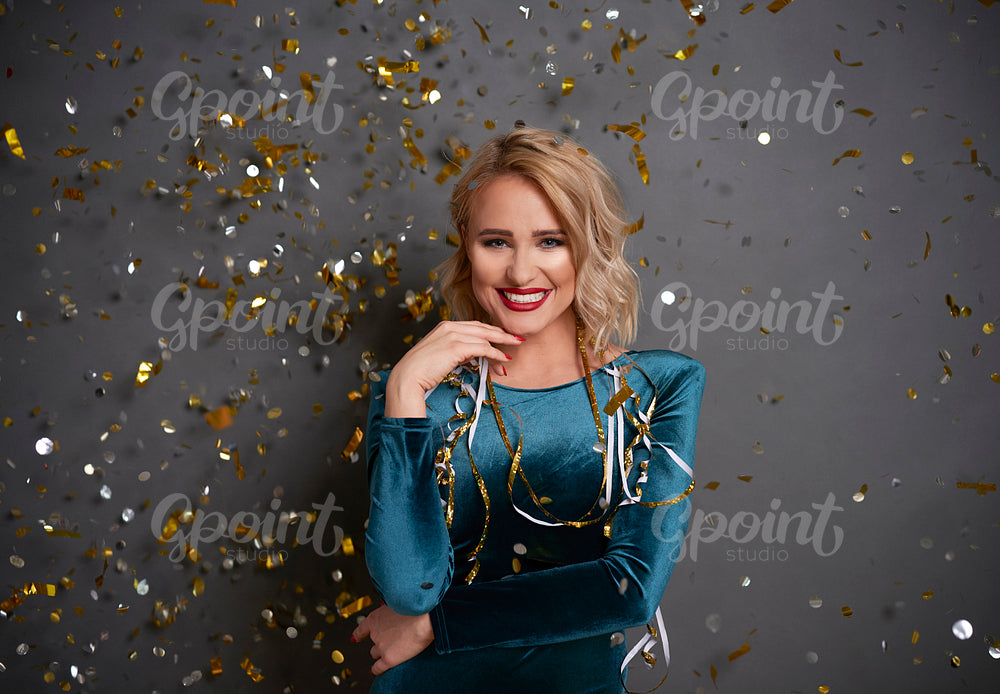 Portrait of glamorous woman under shower of confetti