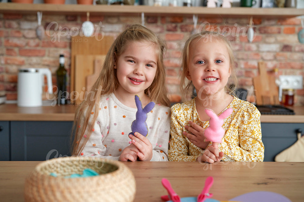 Portrait of two little girls with Easter rabbits on their fingers