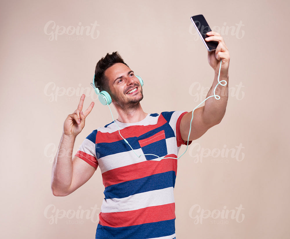 Young man making selfie in studio shot