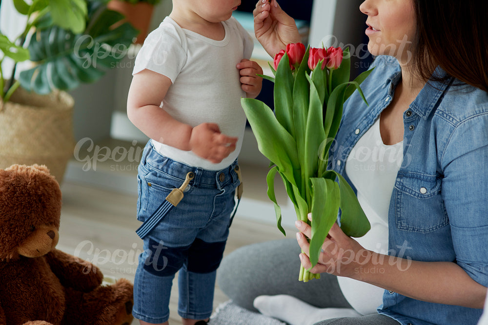 Mother receiving flowers from her toddler boy