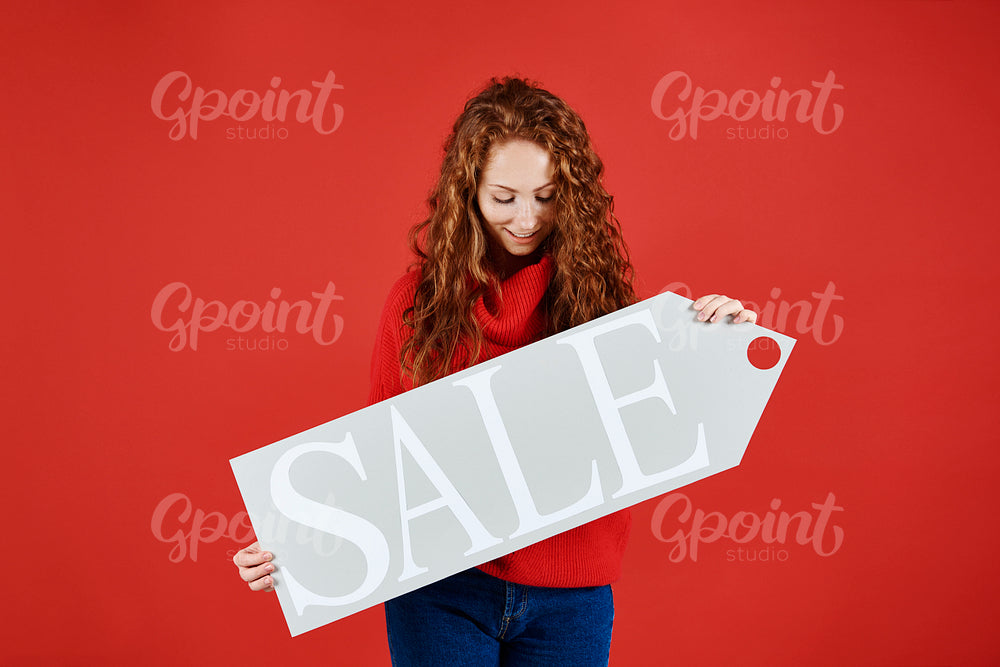 Young girl showing banner of winter sale