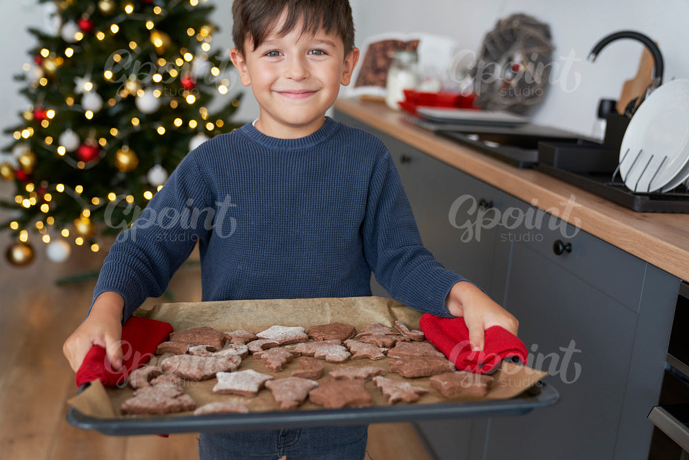 Boy holding a tray full of homemade gingerbread cookies