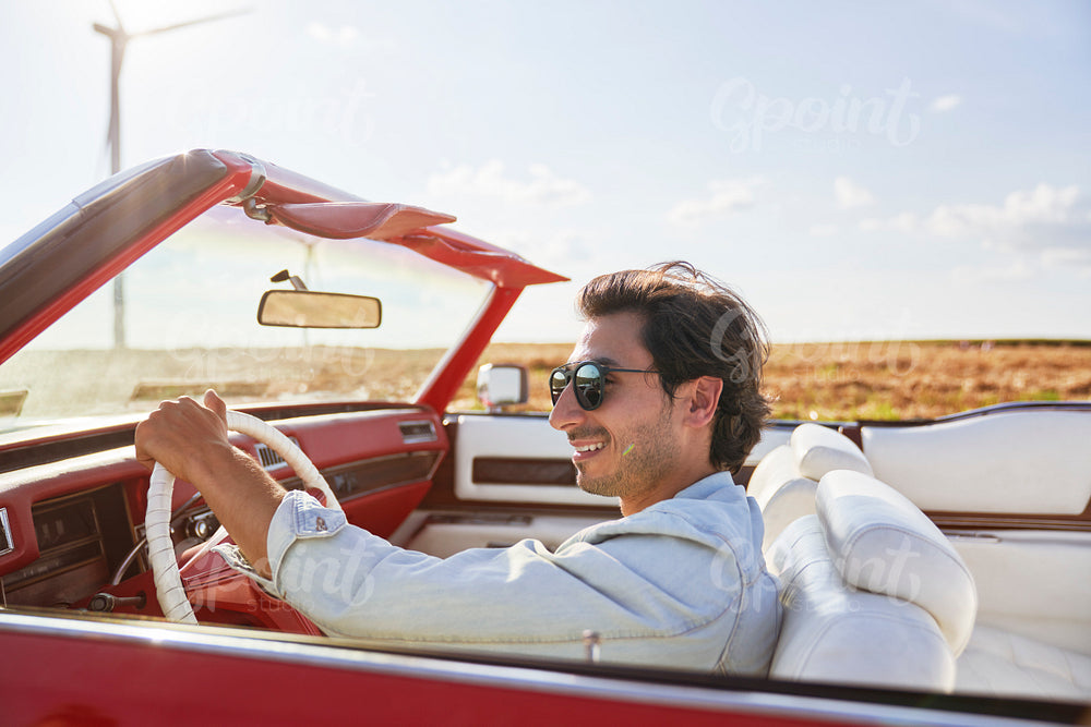 Side view of smiling man driving an old car