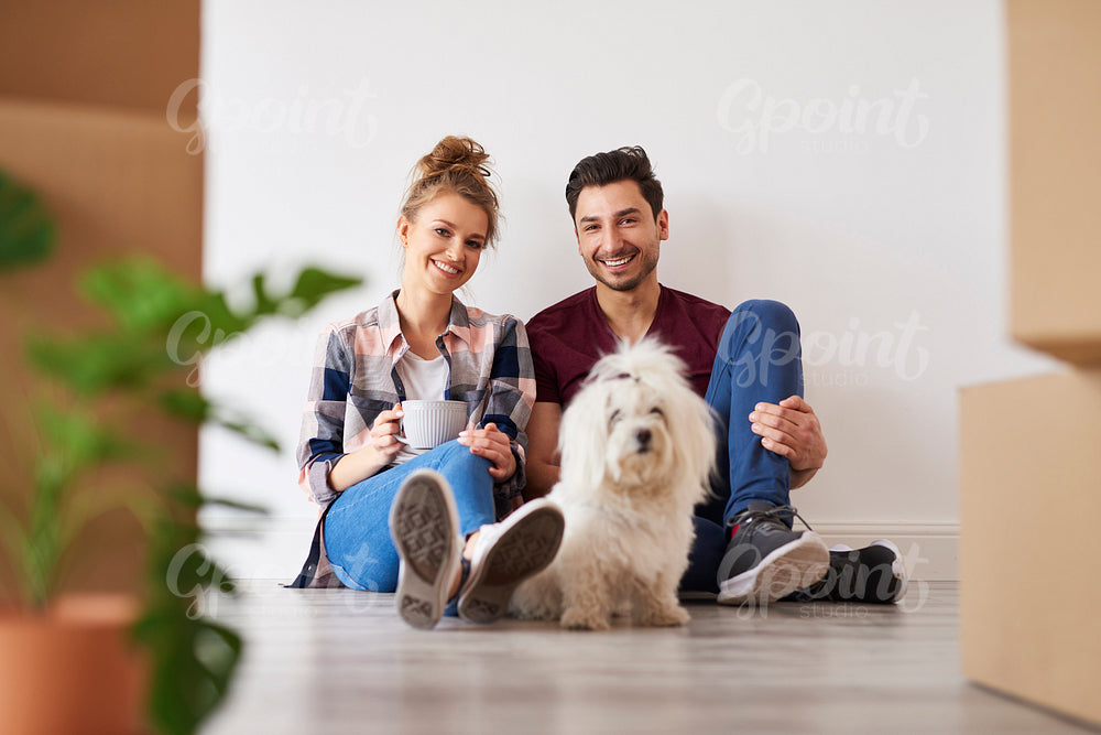 Portrait of smiling couple and dog in their new home