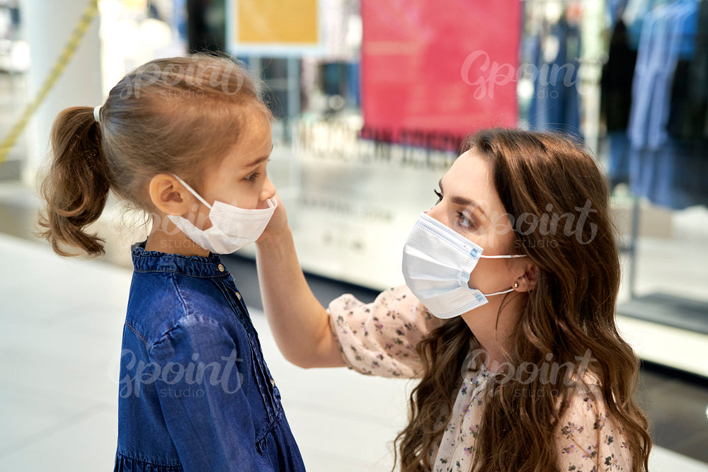Mother putting on a protective mask for her daughter