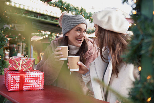 Women warm up with  a cup of mulled wine