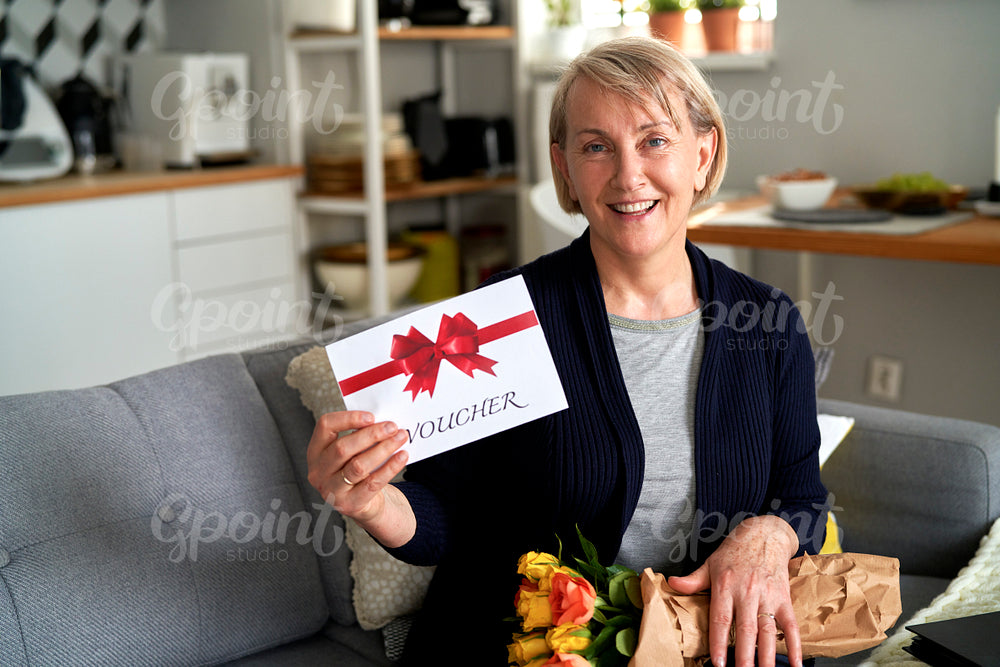 Portrait of mature woman with gift card