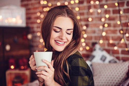 Smiling woman drinking coffee at home