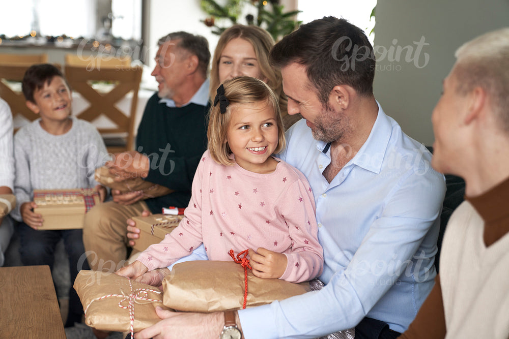 Multi generation caucasian family sitting and holding Christmas presents at home