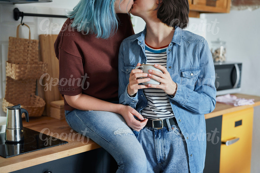 Lesbian couple kissing in the kitchen