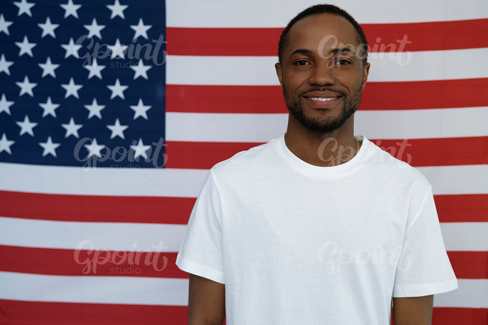 Portrait of cheerful black man on American flag background