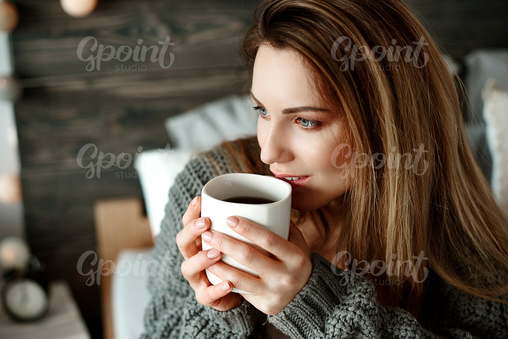 Cheerful woman drinking morning coffee