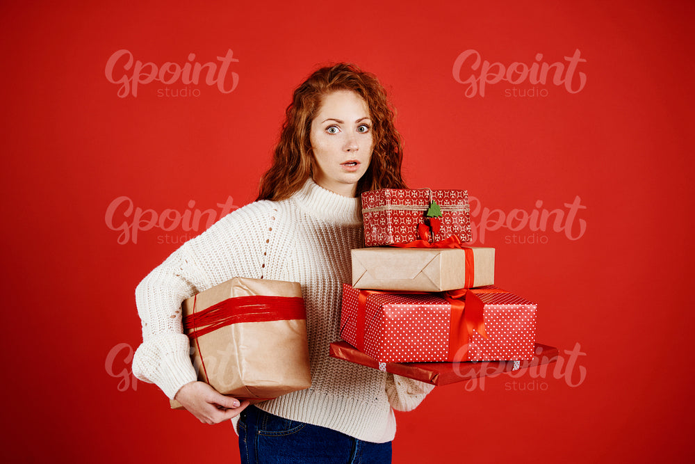 Shocked woman with a stack of christmas presents