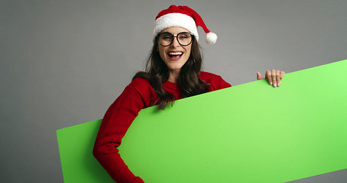 Woman pointing on Christmas banner with copy space