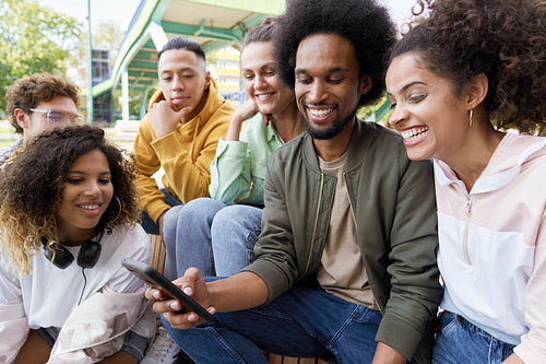 Young people sitting and staring at cell phone
