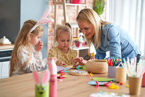 Mom with two girls preparing Easter decorations at home