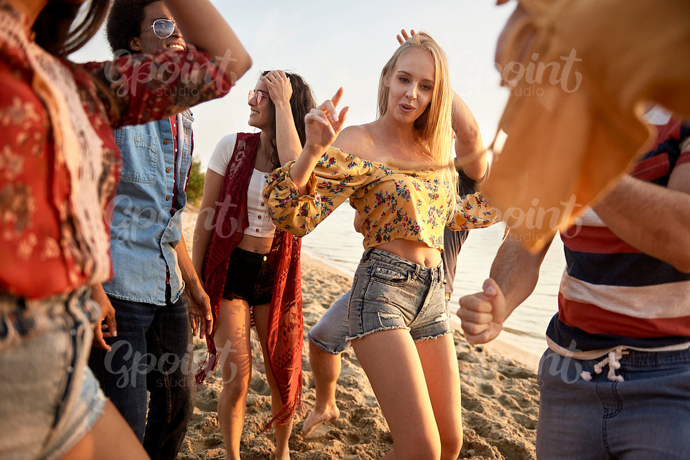 Group of young people dancing at sunset